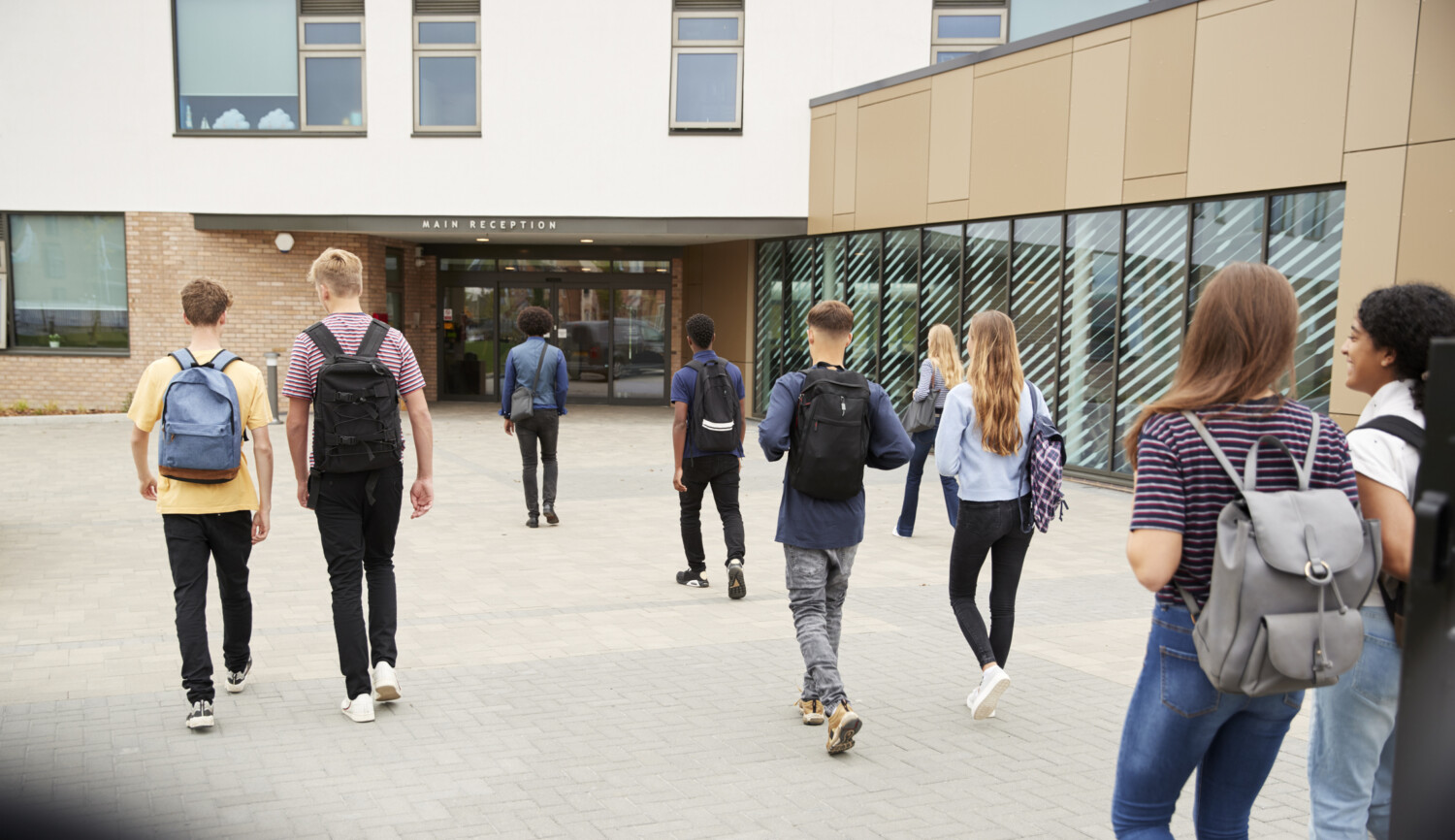 Brevet des collèges : il ne sera pas obligatoire pour le passage en seconde Rear View Of High School Students Walking Into College Building Together