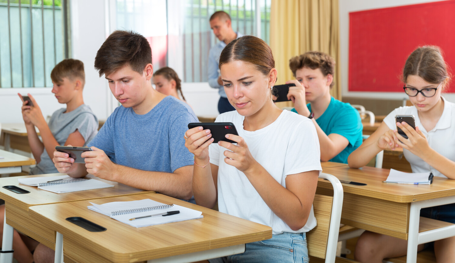 écrans téléphones élèves Pupils with smartphones sitting in class