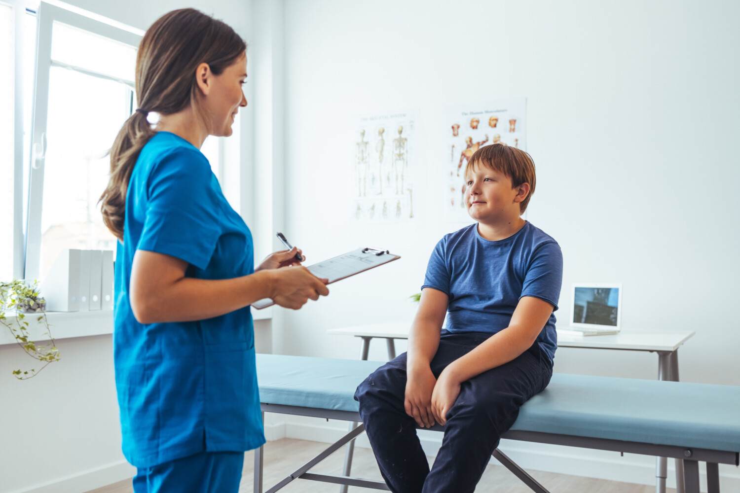 Teenage Boy And Doctor Have Consultation In Hospital Room