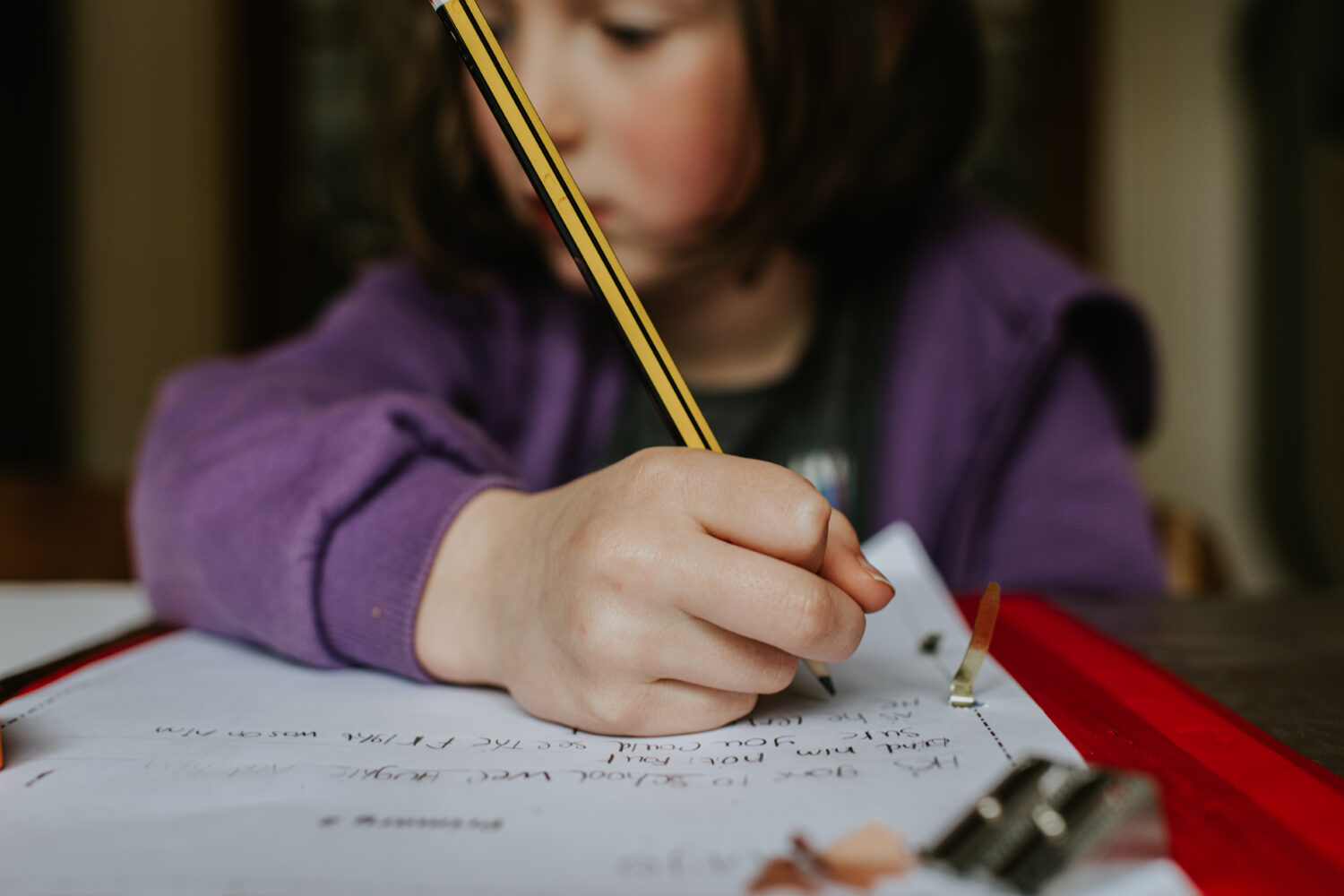 Ecriture manuscrite chez les enfants : des bénéfices sur l’identification des lettres et la lecture Focus on a pencil that a little girl holds as she does homework