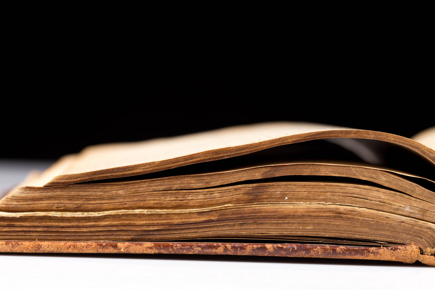 ancient book shot on black background. The book is in bad condition.