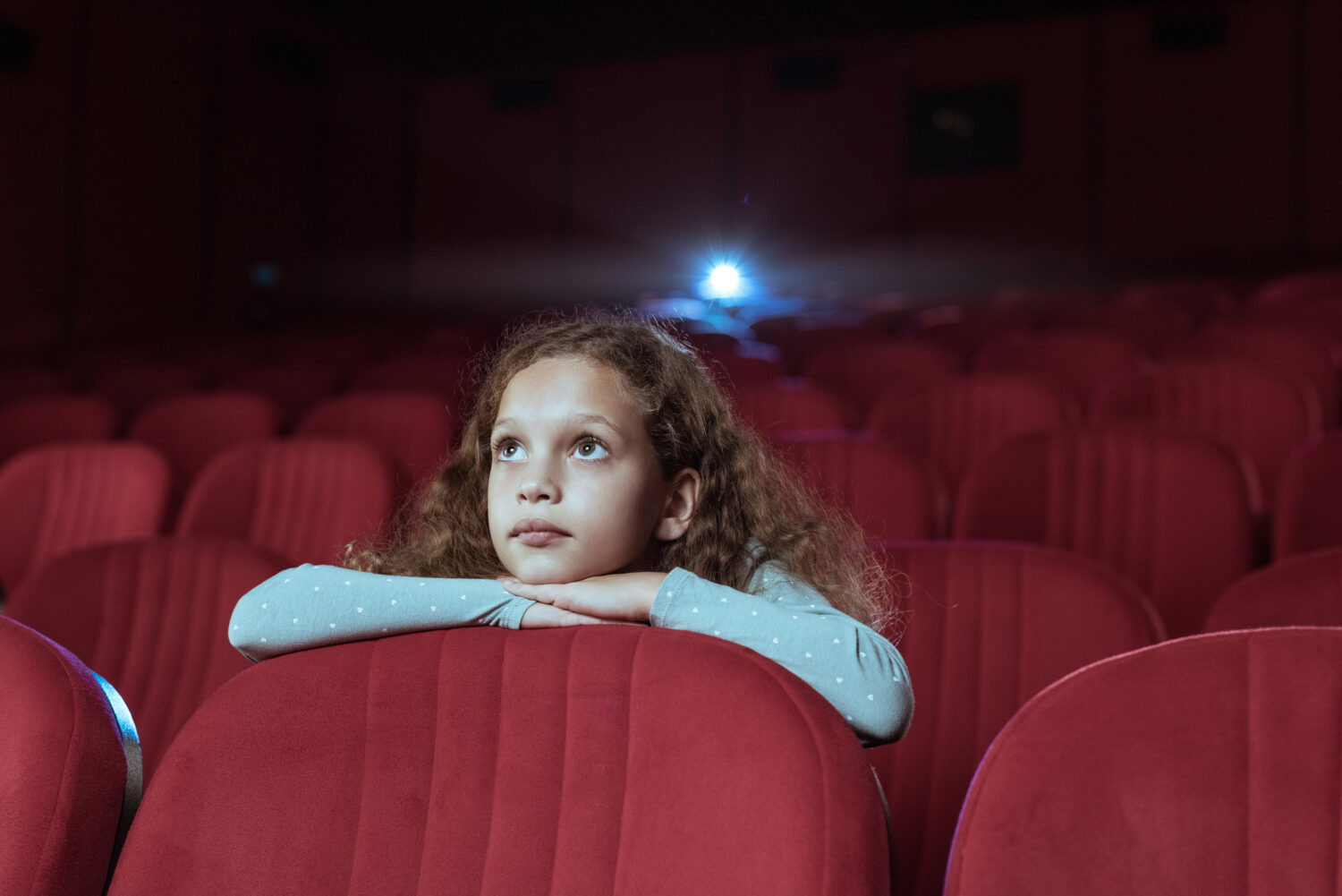 Little girl in cinema watching movie