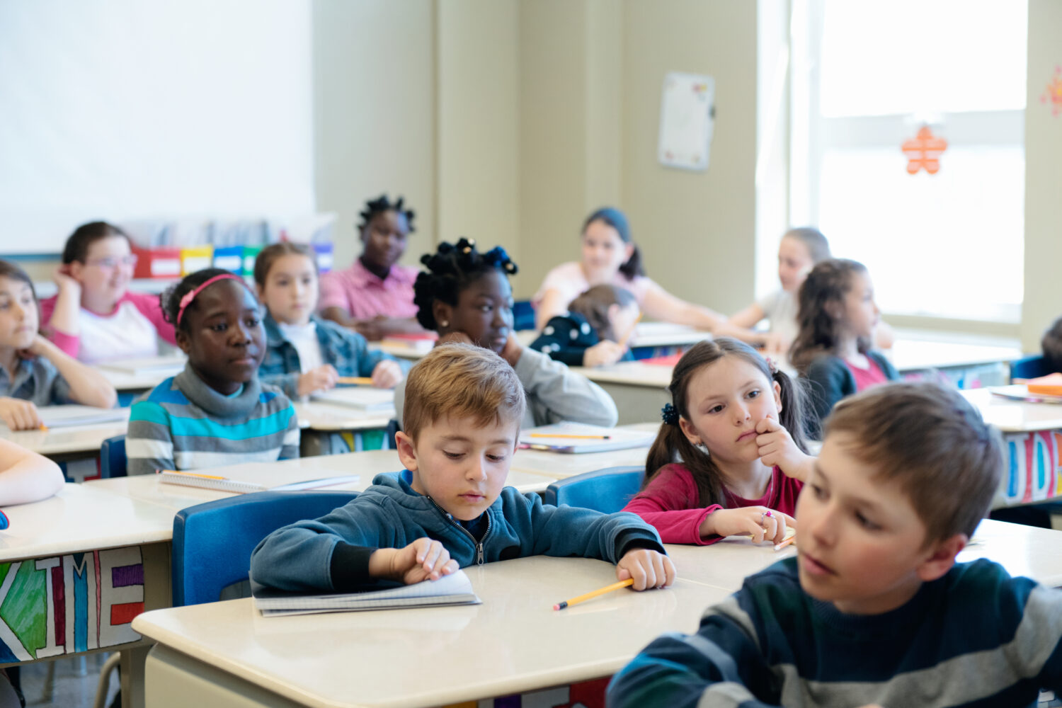 Multi-ethnic students sit into the class for the first day at school
